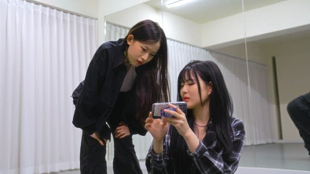 연습 영상을 보고 피드백을 주고받는 댄서들