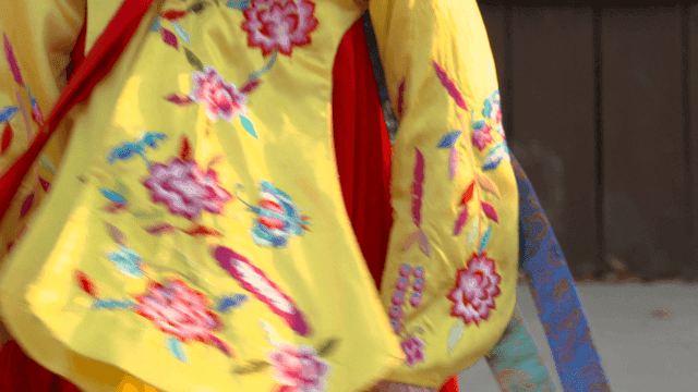 Woman wearing traditional Korean hanbok and dancing with fan