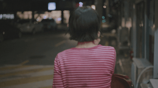 Woman walking on a night street while on a call