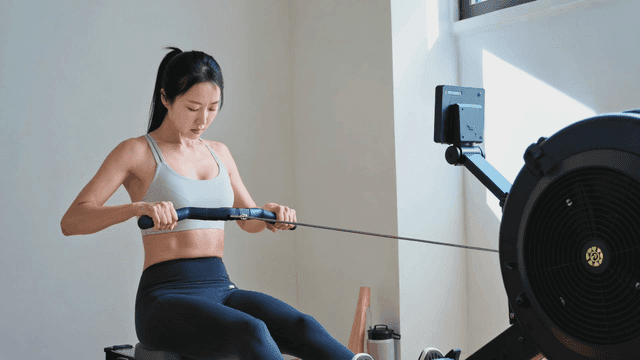 로잉 머신으로 운동하는 여성