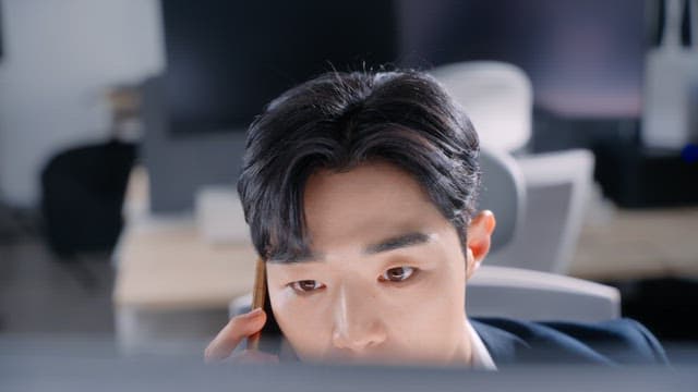 책상에서 전화 통화하는 남자