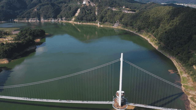 Scenic bridge crossing tranquil lake.