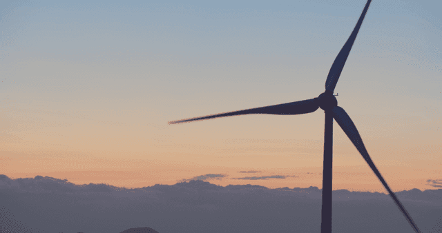 Wind turbine against a sunset sky