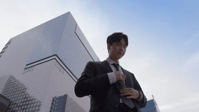 Office worker standing in front of a tall building