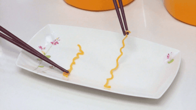 Noodles lifted from pot to bowl