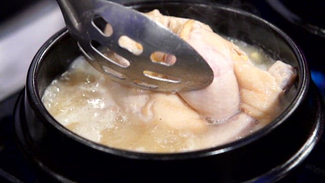 Chicken boiling in a pot with broth