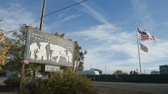 Welcome sign and American flag in a town