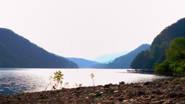 Serene lake surrounded by lush mountains in the afternoon