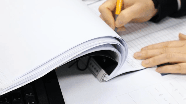 책상에서 문서에 글을 쓰는 사람