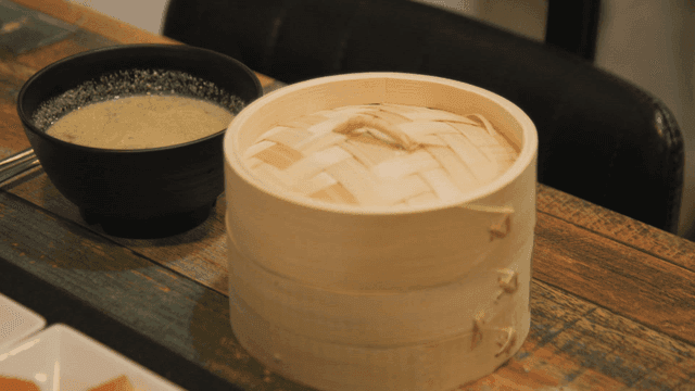Soup and bamboo steamer on table