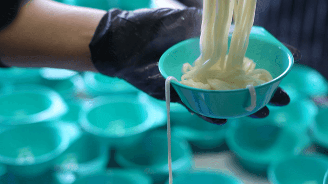 Noodles being placed into a bowl