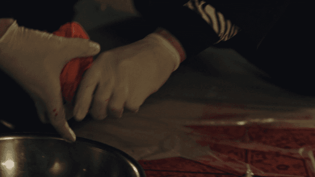 Wiping a red stain on the floor and wringing a cloth