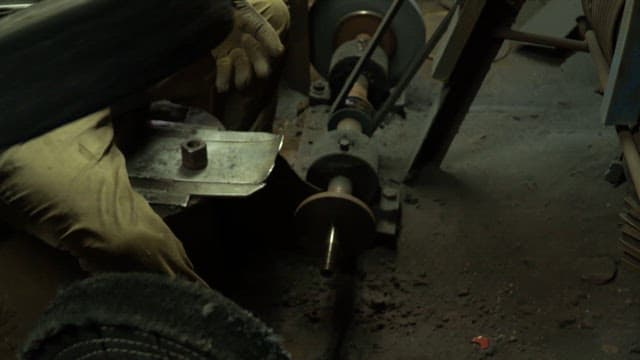 Worker handling machinery parts in a factory