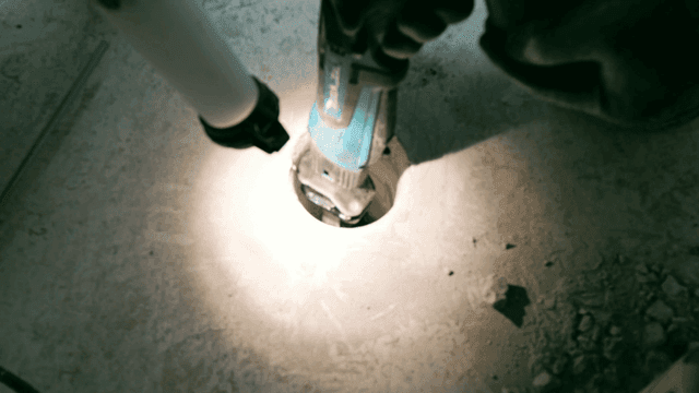 Board cutter cutting floor under flashlight