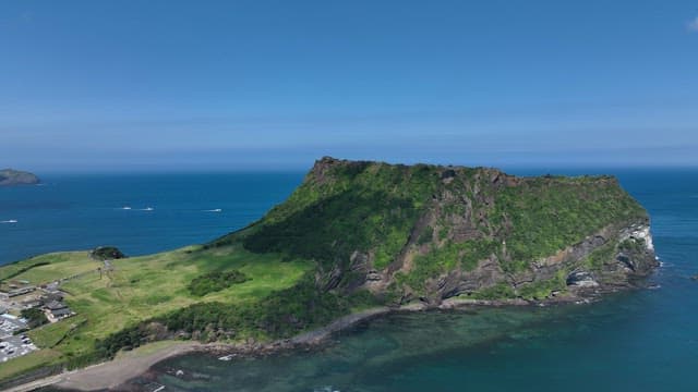 Seongsan Ilchulbong with Lush Greenery and Serene Sea on a Sunny Day