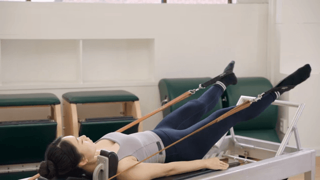 Woman practicing pilates on a reformer