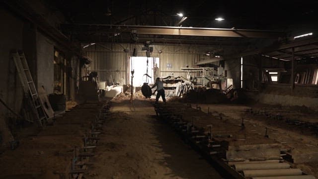 Worker handling metal parts in a factory