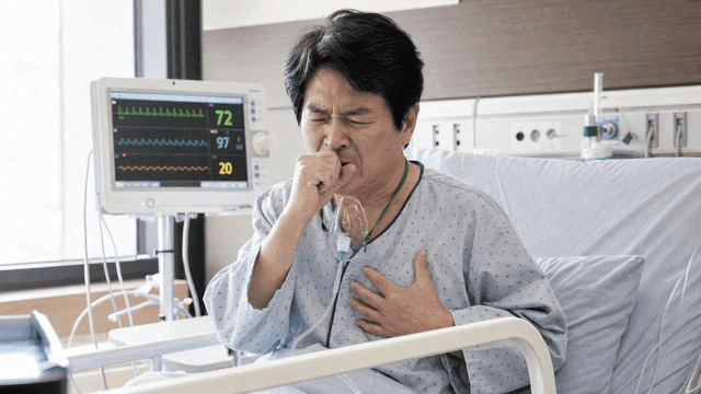 Patient coughing in a hospital bed