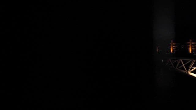 밤에 불이 켜져 빛나는 물 위의 다리