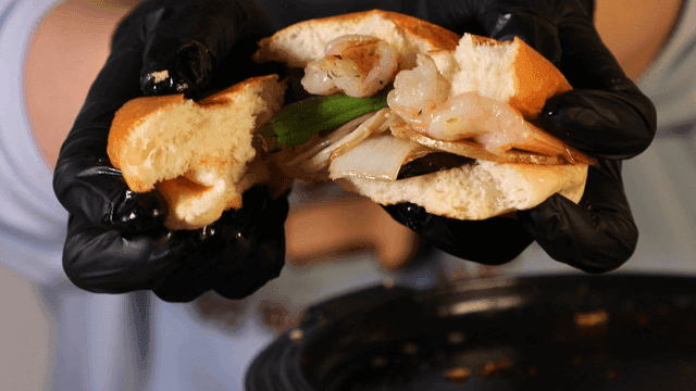 Fresh vegetable and shrimp sandwich in hand