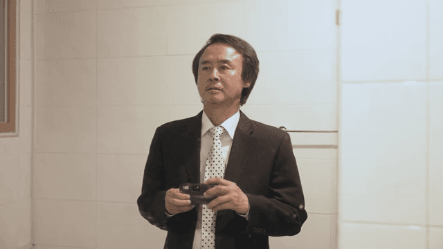 정장을 입고 거울 앞에서 사진을 찍는 남자