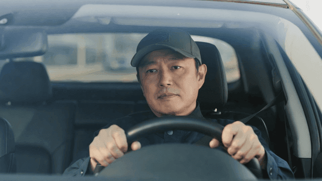 Man wearing hat driving car on clear day
