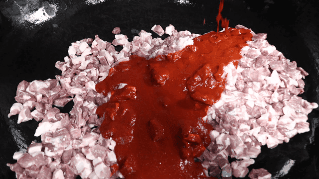 업소용 큰 냄비 안 고기 조각들에 부어지는 매운 소스