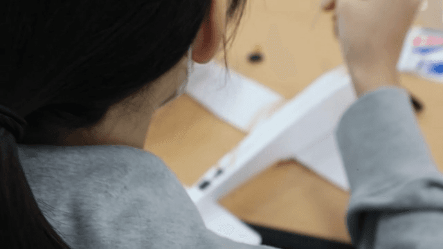 Elementary school students assembling model airplanes
