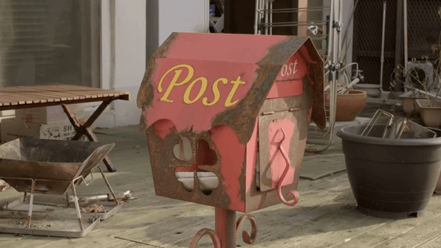 나무 데크 위의 녹슨 우체통