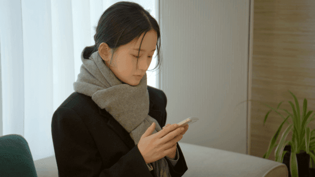Woman using her smartphone on sofa