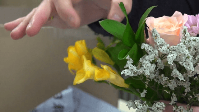 사람이 화려한 꽃다발을 정리하는 모습