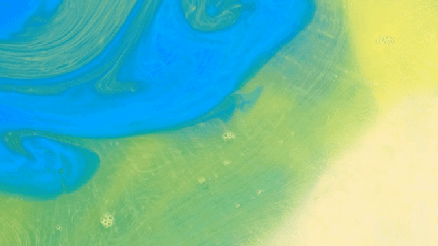 파란색, 초록색, 노란색 액체가 혼합되는 추상적인 패턴