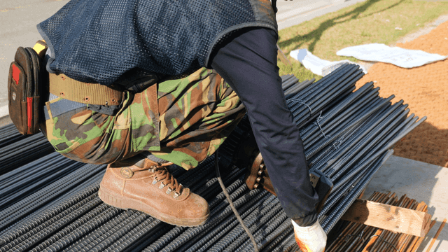Worker cutting steel bars at a construction site