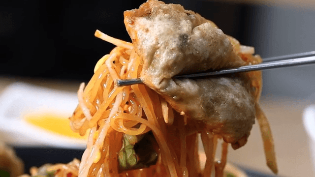 쫄면을 곁들인 만두를 집은 젓가락