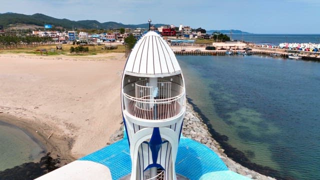 Coastal town with a unique lighthouse and sculpture