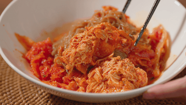 흰 그릇에 담긴 매운 비빔 국수