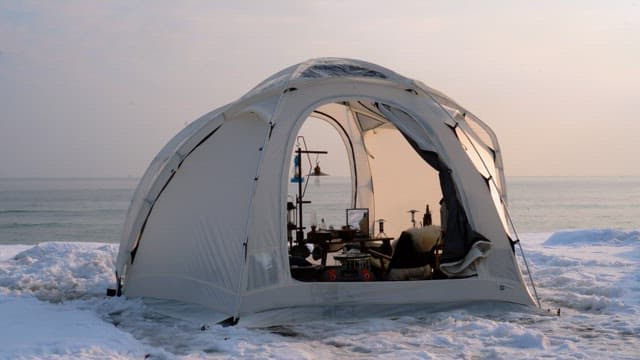 Camper in tents pitched on a snow-covered beach