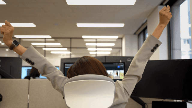 Female office worker stretching at her desk