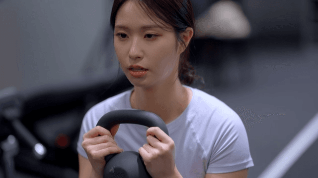 Young woman doing kettlebell squat exercise