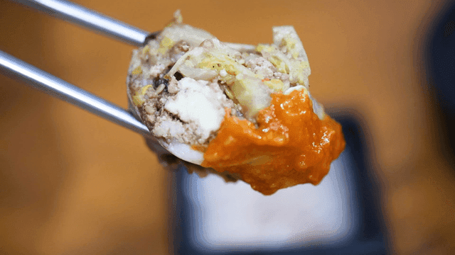 Chopsticks holding Abai sundae served with spicy ssamjang