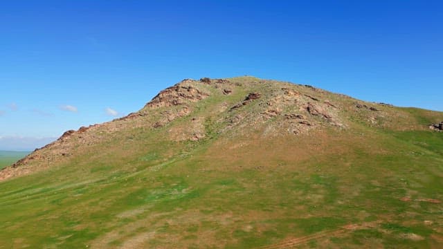 Grassy hill under a clear blue sky