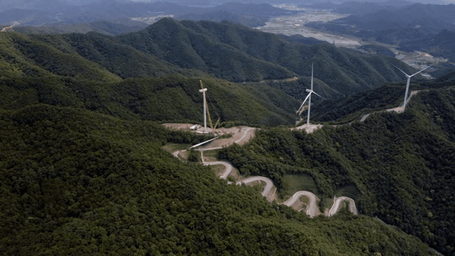 Wind turbines on a lush green mountain