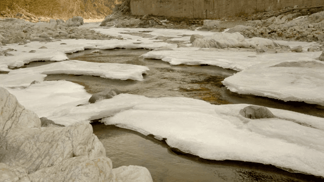 Flowing river with ice and rocks