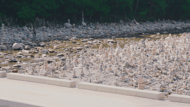 돌탑이 많은 강가에서 휴식을 취하는 사람들