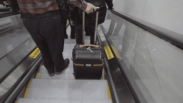 에스컬레이터에서 캐리어를 든 사람