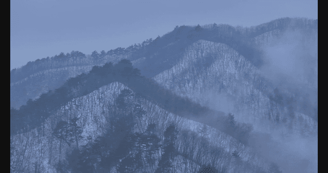 Snow-covered mountains with mist