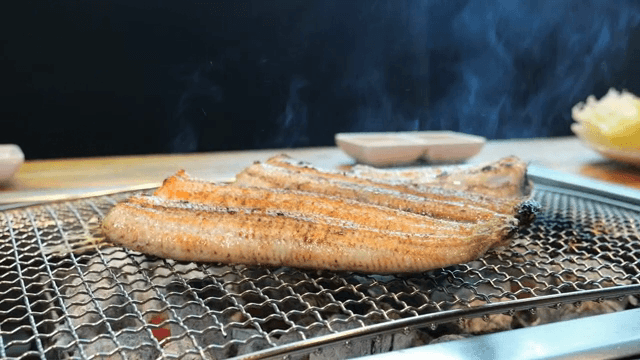 연기가 나는 테이블 위의 장어구이