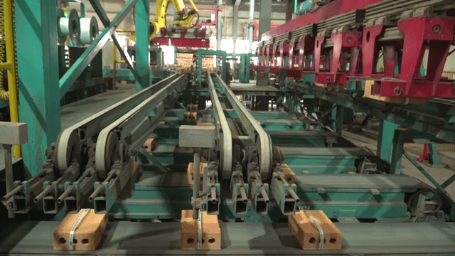 Robotic arm moving bricks on a conveyor belt