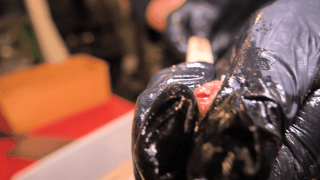 검은 장갑으로 꼬치에 꽂아지는 생고기