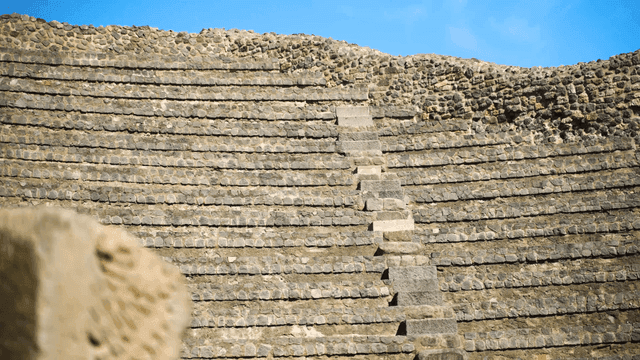 Ancient stone amphitheater under blue sky